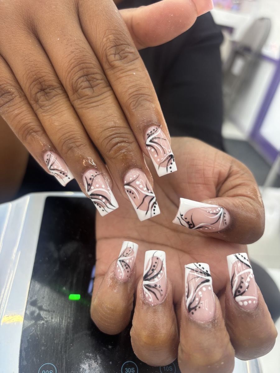Long square nails with a hand-painted black and white swirl design over a nude base, by Glamorous Nail Shop