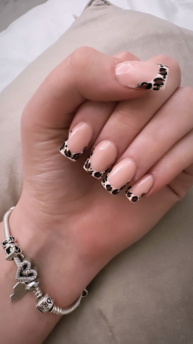 Square nails with leopard-print French tips finished with fine gold detail