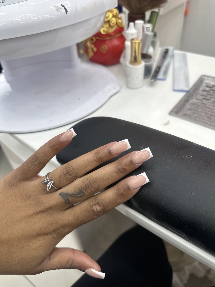 Classic white French tips photographed at the manicure station inside Glamorous Nail Shop